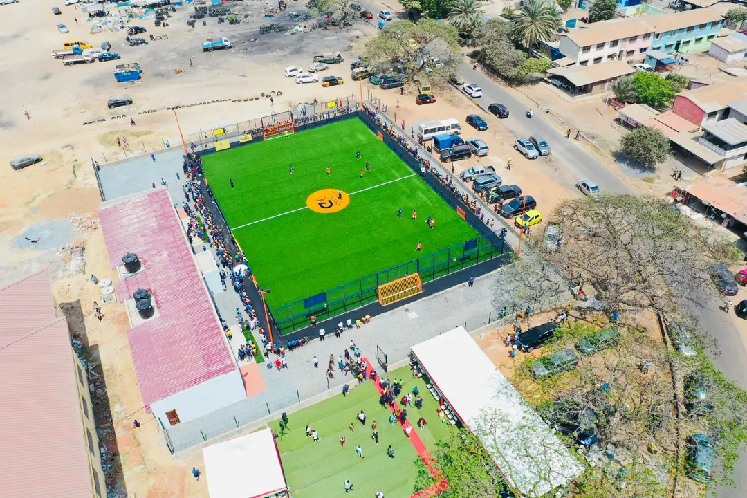 Een drone foto van een Cruyff Court waarop gevoetbald wordt in Afrika