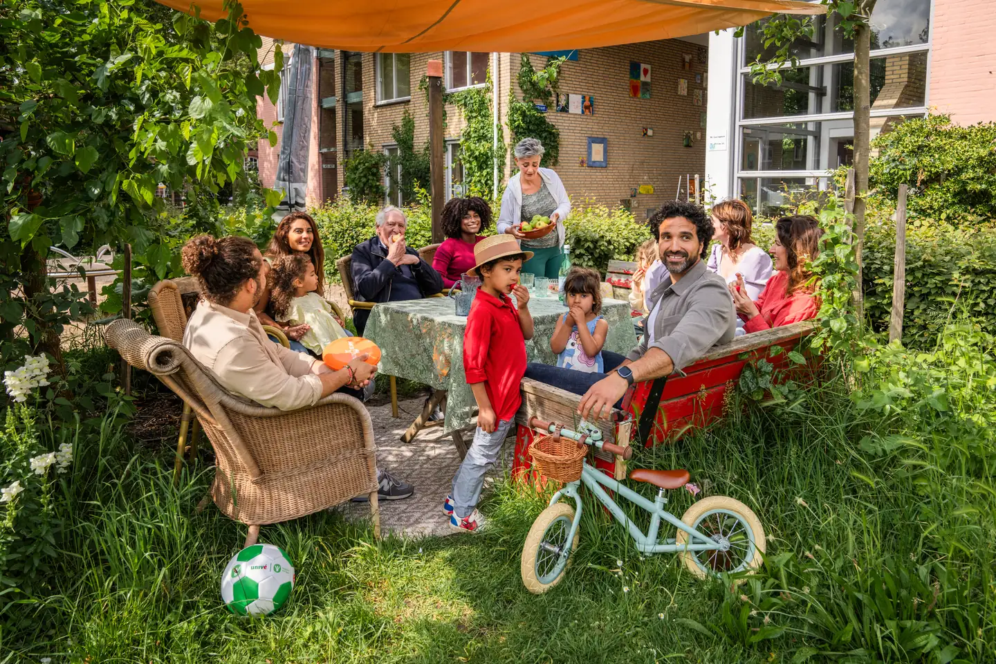 De buurtbewoners zitten relaxt op stoelen en bankjes samen in de schaduw onder een parasol